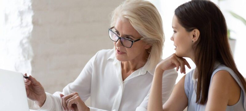 Diverse female colleague brainstorms working on laptop