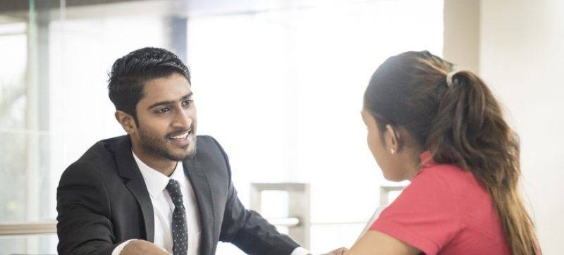 Two young Sri Lankan business colleagues in modern office