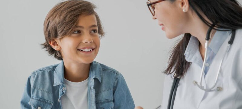 School boy and doctor have consultation in hospital room