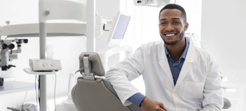 Highly qualified young dentist posing at modern clinic
