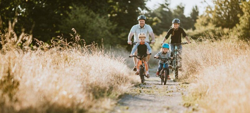 Family Mountain Bike Riding Together on Sunny Day