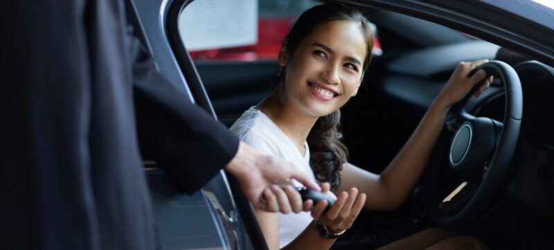 Woman buying a car at the showroom